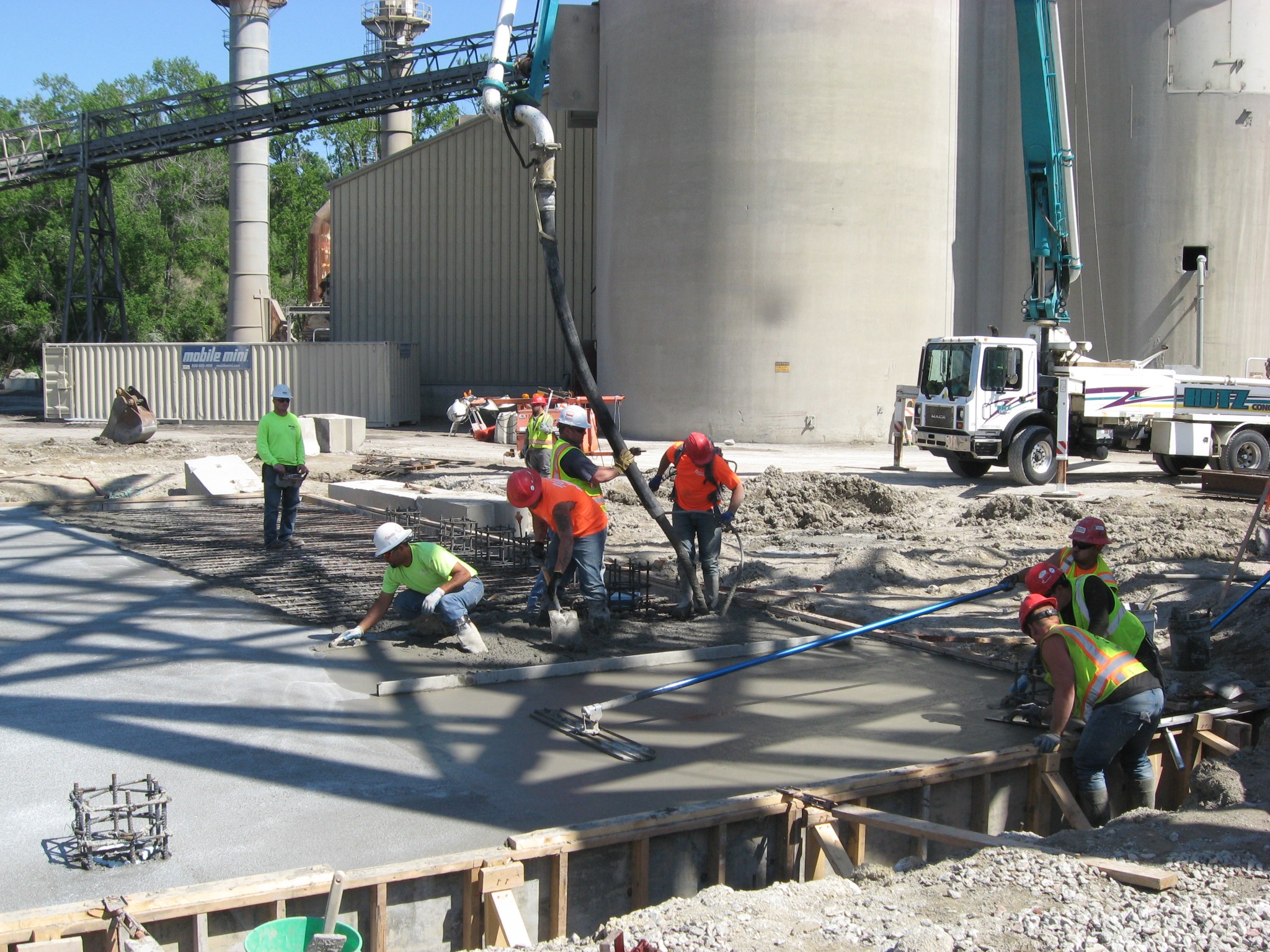 Concrete placement and finishing at an industrial facility.