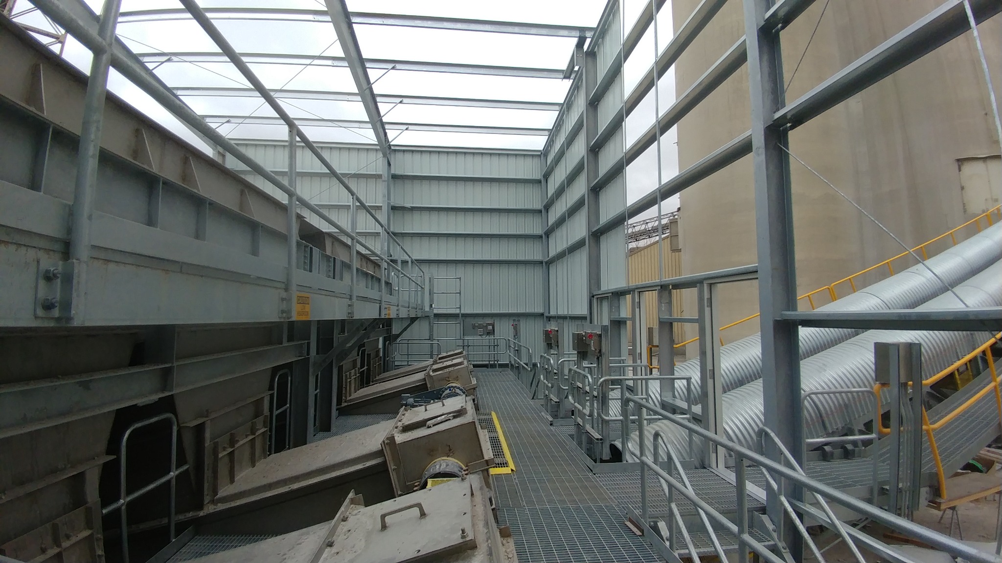 Material handling equipment and access walkways inside a plant building.